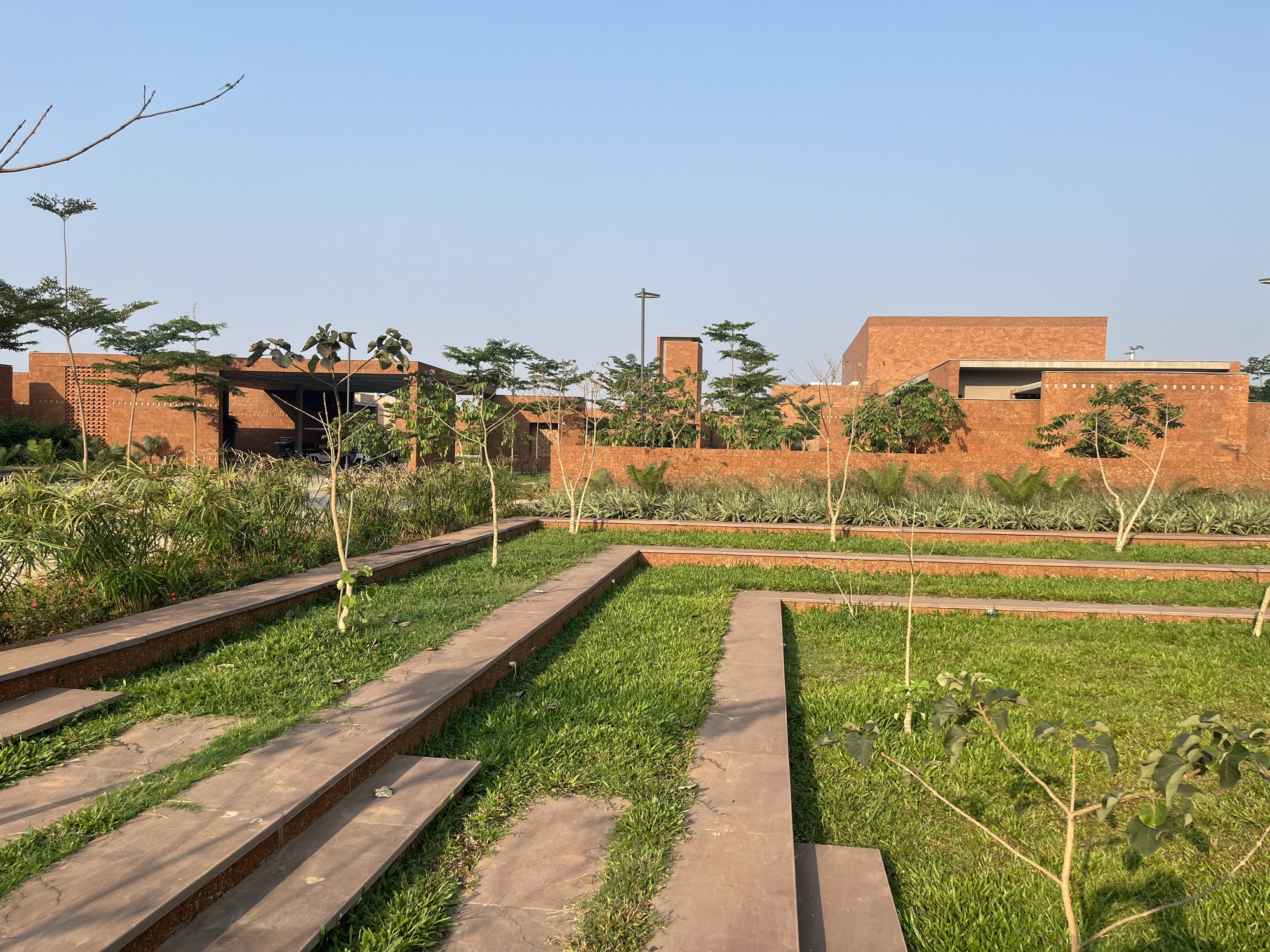 Landscaped rear garden with planted terraces and the brick complex on the horizon