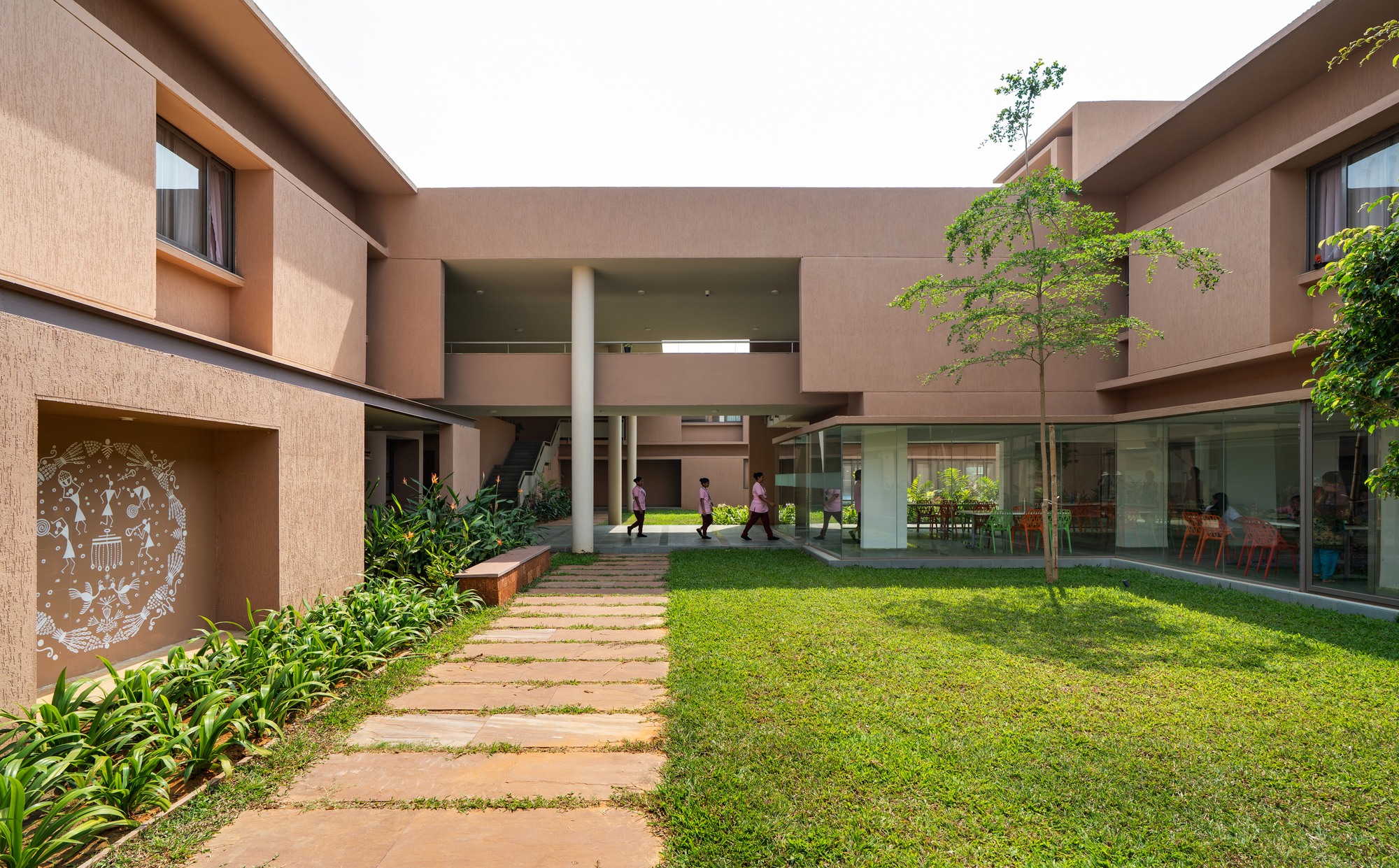 Interior courtyard with a lawn, red sandstone path and perforated jali screens on the upper level