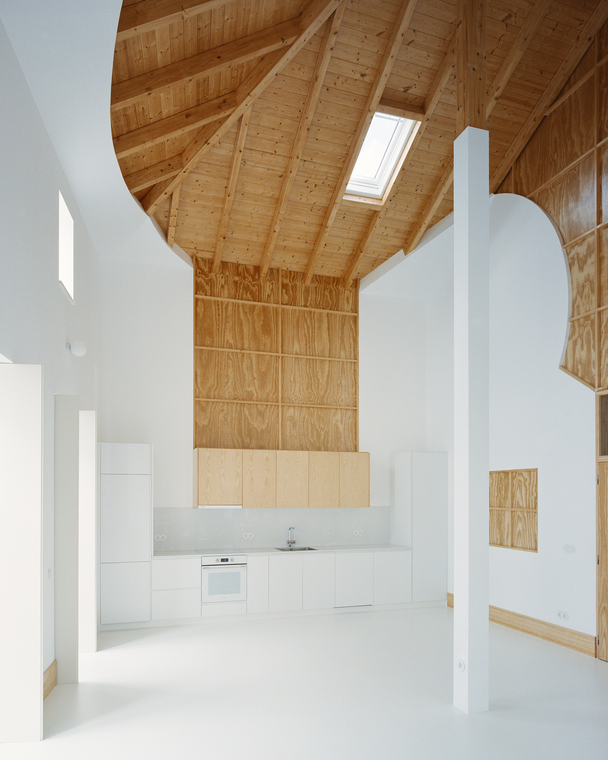 Frontal view of the kitchen with the plywood chimney panel and the curved roof above