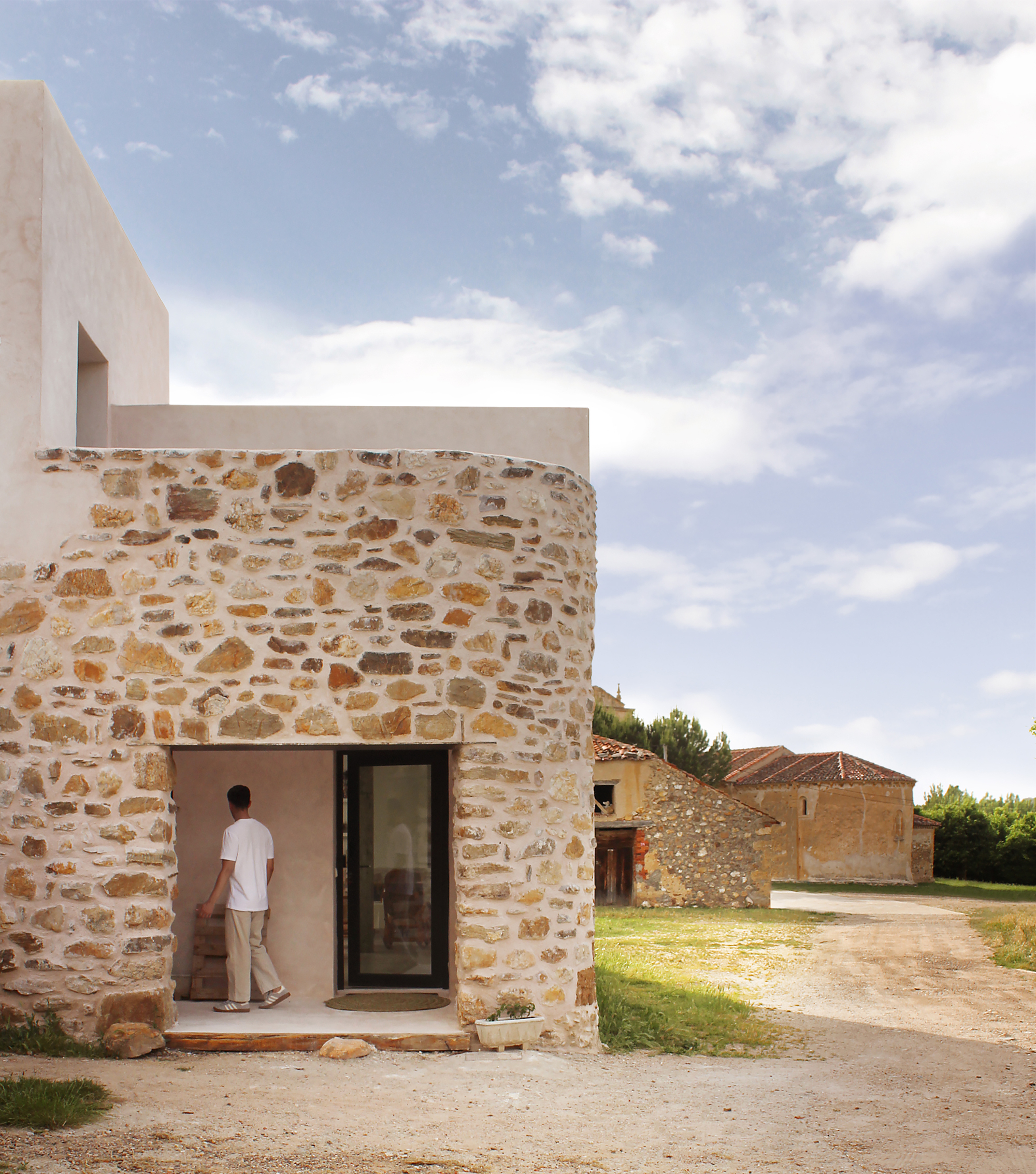 Curved stone wall and entrance door at the corner of the converted stable