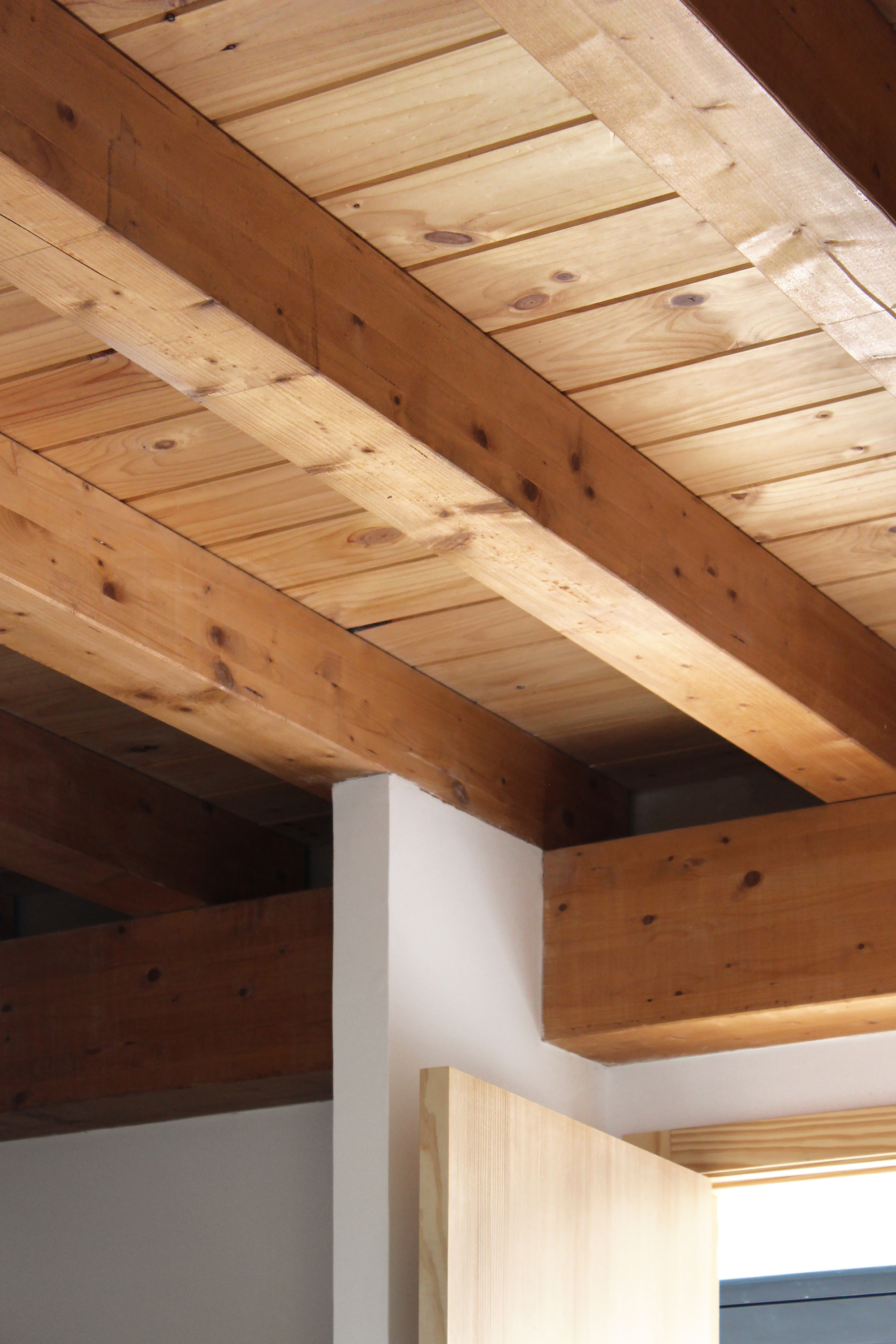 Close-up of the original heavy timber roof beams and tongue-and-groove pine ceiling
