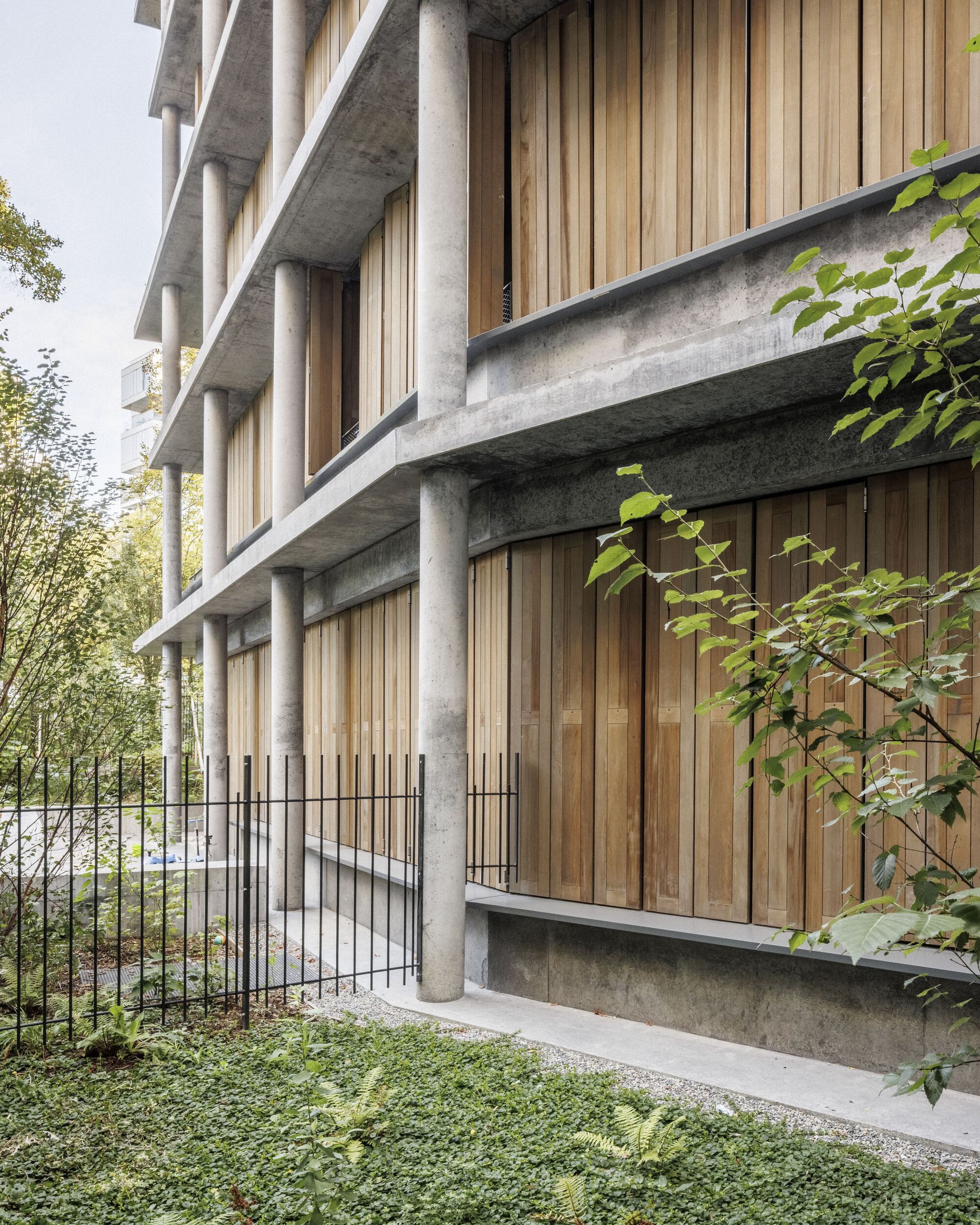 Detail of the round concrete columns and vertical timber screens on the lower floors