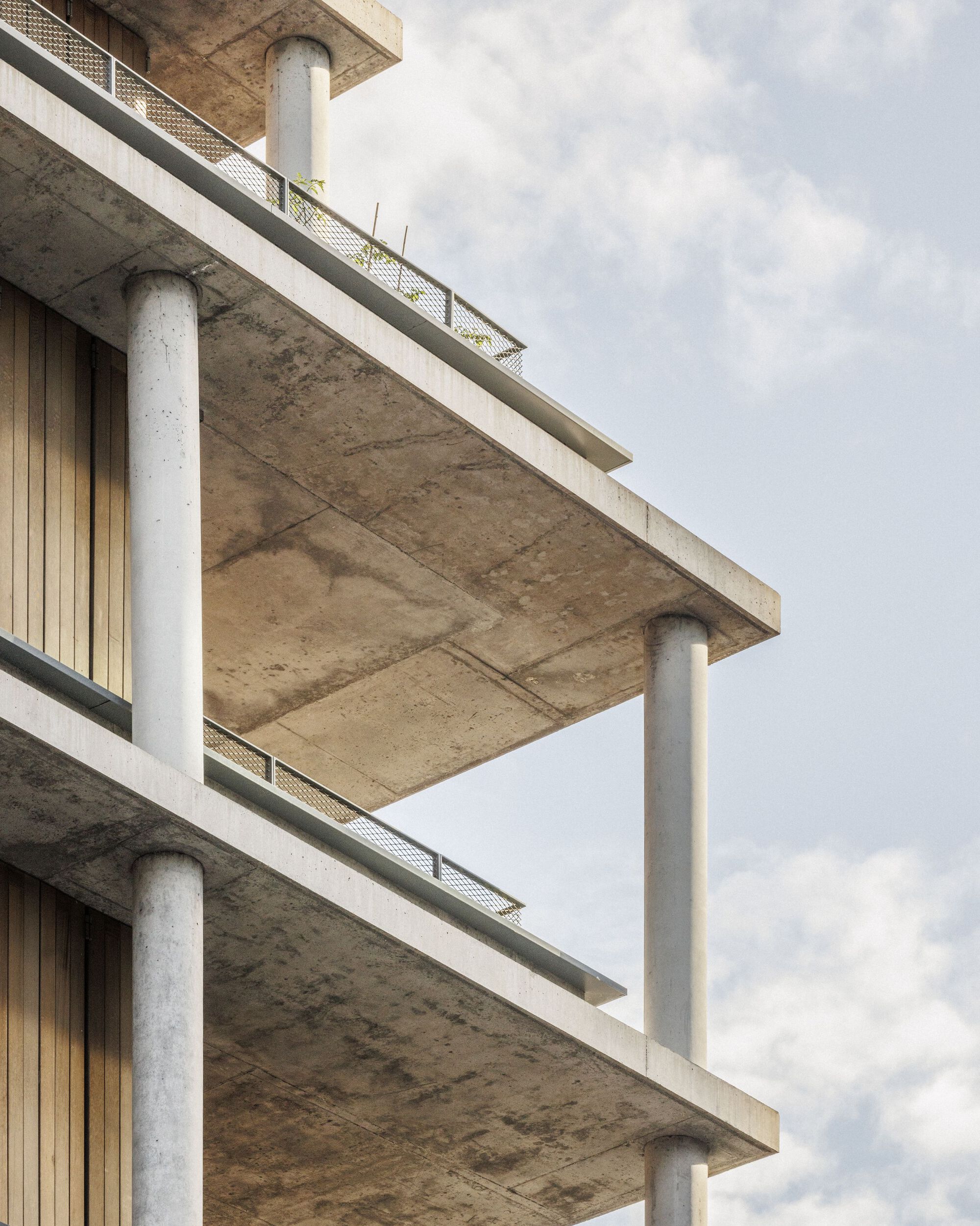 Close-up of the cantilevered concrete slabs and round columns at the building corner