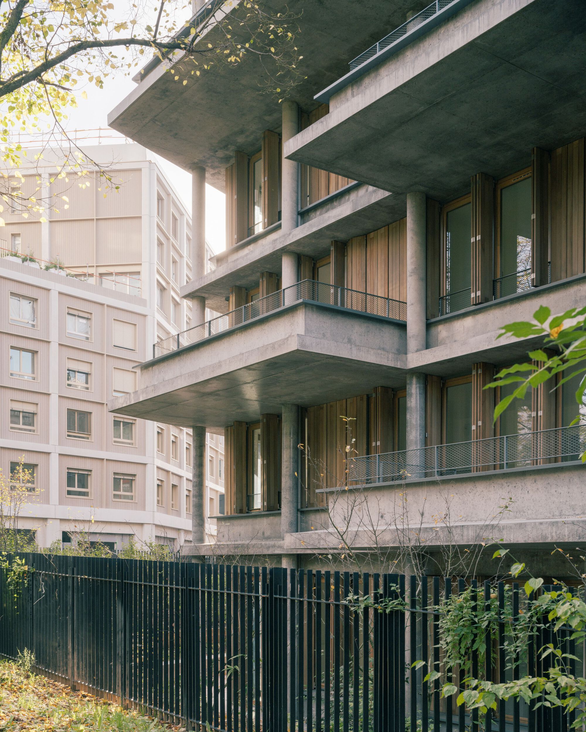 Cantilevered concrete balconies stepping out from the main facade into the surrounding park