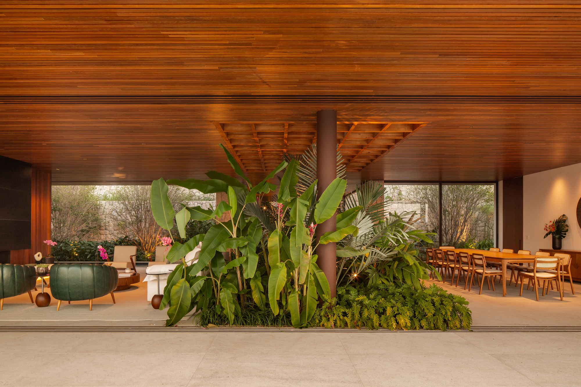 Central vestibule with a large planted bed separating the living and dining zones under the timber ceiling