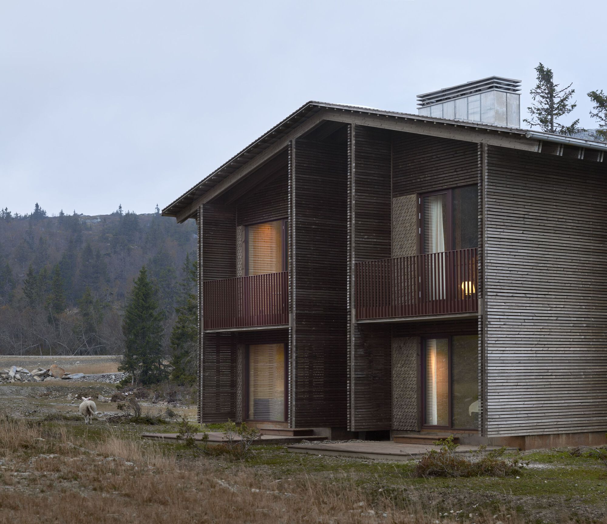 Full two-storey volume with balconies and ventilated timber facade