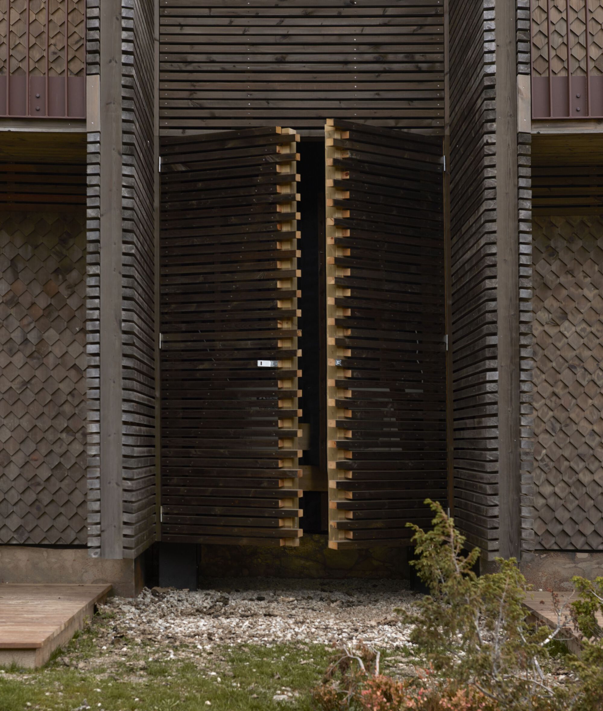 Entry gate: slatted timber screen doors set within the facade depth